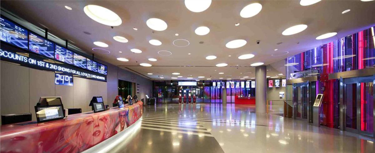 Cinema lobby with a curved illustrated ticket counter and polished floor
